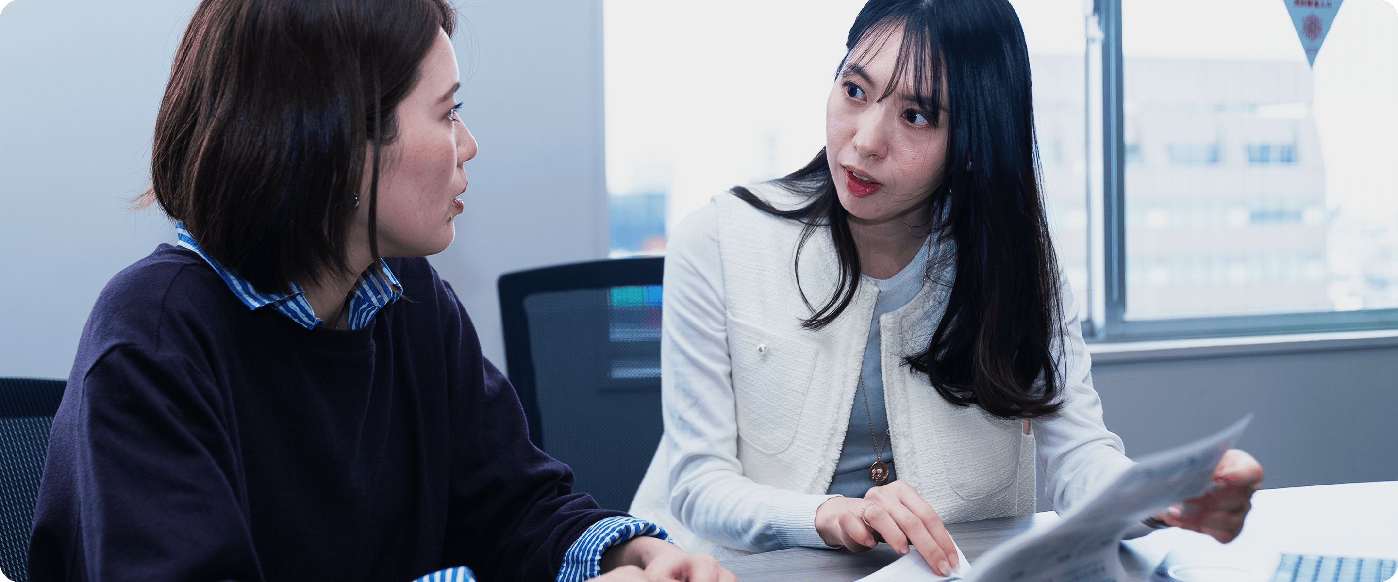 2人の女性社員が話し合うシーン