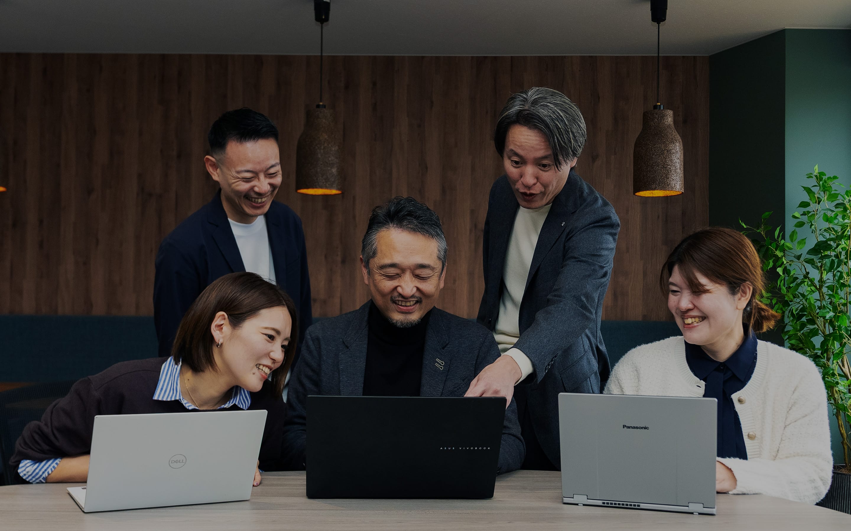 社員メンバーが会議室で同じモニターを見ているシーン